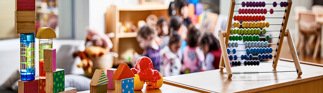Jouets sur un meuble avec de jeunes enfants qui jouent à l'arrière-plan