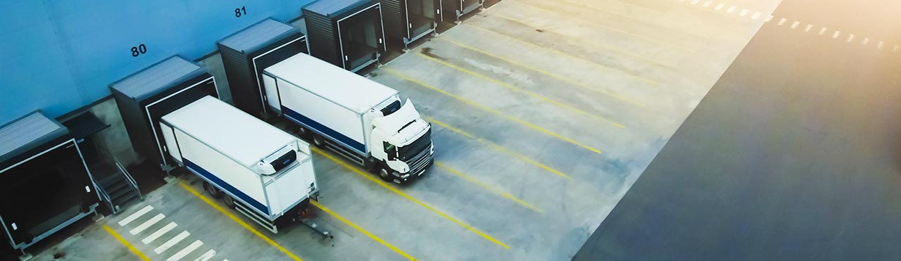 Des camions se trouvent sur les quais de chargement d'une entreprise logistique.