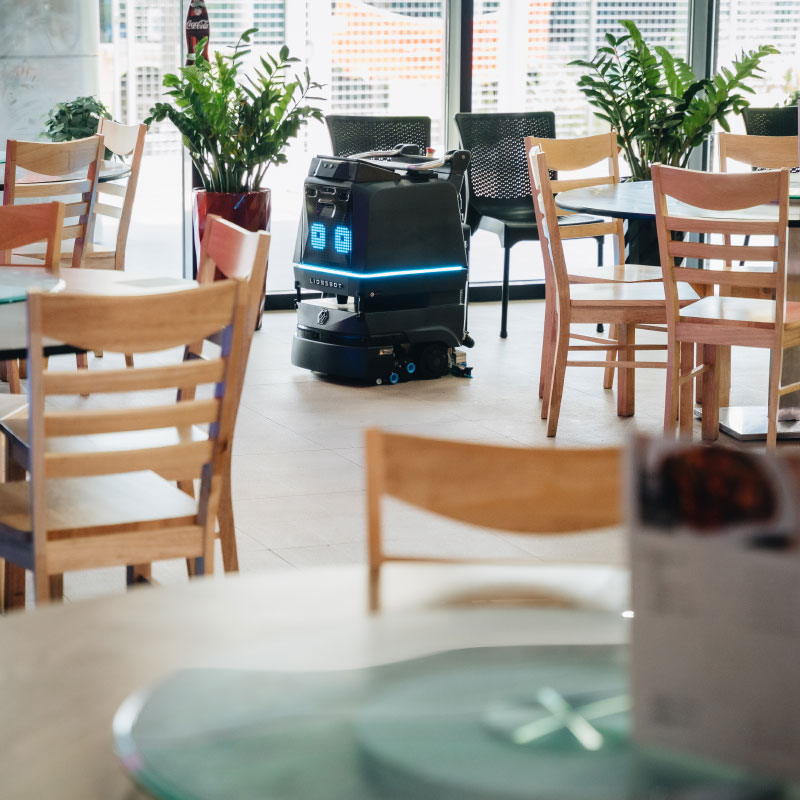Le robot nettoyeur R3 nettoie entre les tables et les chaises