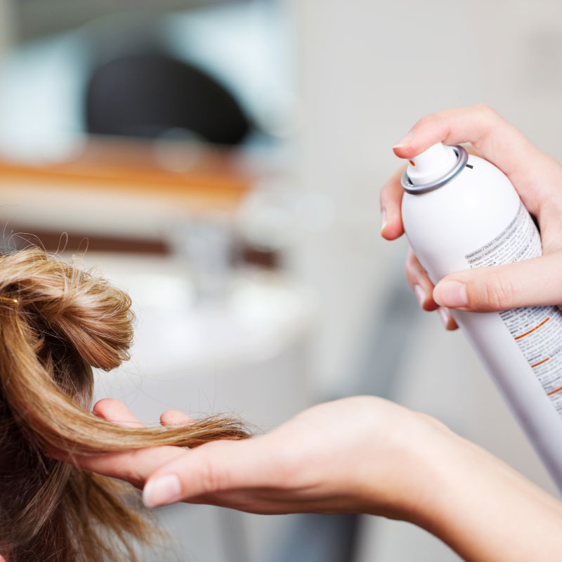 La laque est appliquée sur les cheveux dans les salons de coiffure